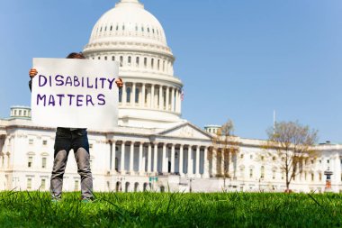 Washington'da ABD başkenti önünde engellilik önemli olduğunu belirten pankart tutan çocuk protestosu