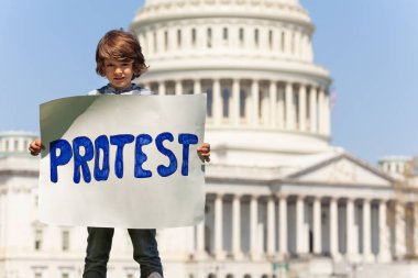 Washington'da ABD'nin başkenti önünde protesto gösterisi düzenleyen çocuk, protesto pankartı yla protesto etti