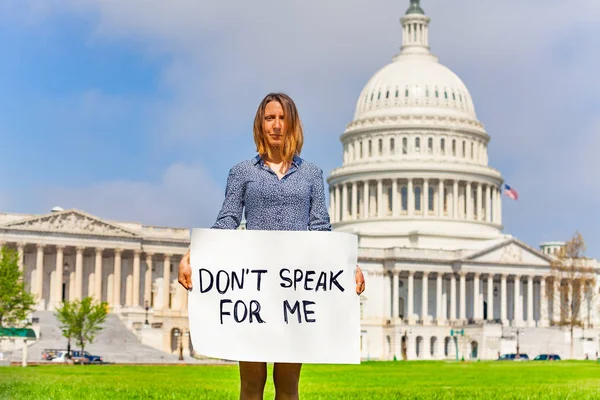 Woman protest in front of the USA capitol in Washington holding sign saying don\'t speak for me
