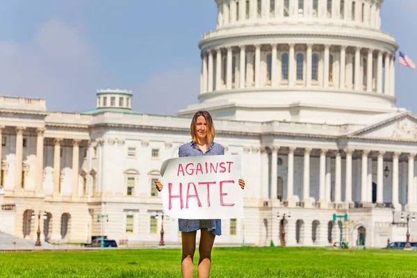 Woman protest in front of the USA capitol in Washington holding sign saying  I\'m Against hate