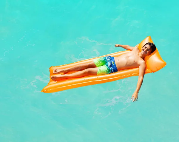 편안한 행복한 소년은 위에서 선글라스보기를 매트라에 물에서 — 스톡 사진