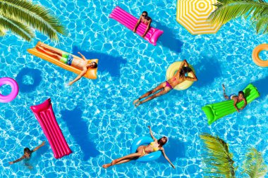 Birçok çocuk ve kadın desen yüzen, köşelerinde palmiye ağaçları ile yukarıdan havuz su görünümünde yüzme