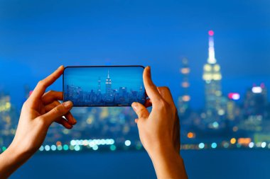 Turist el Hudson limanı üzerinde gece New York cityscape fotoğraf çekmek, Abd
