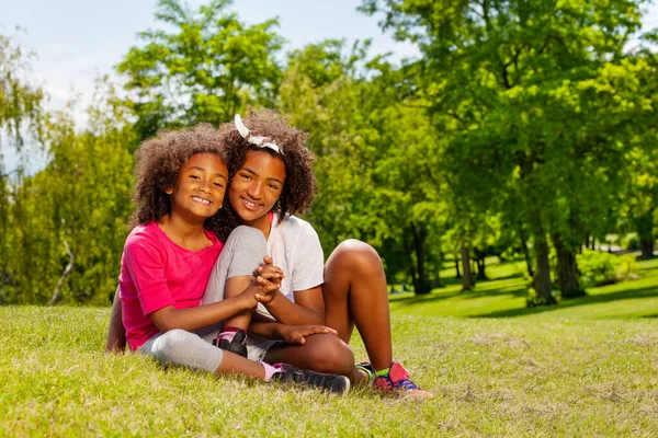 Two Girls Sisters Hold Hands Sitting Lawn Park — Stock Photo, Image