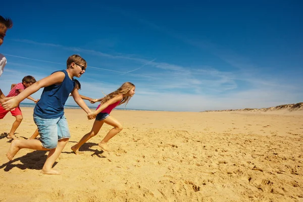 Chłopcy Dziewczęta Biegają Szybko Piaszczystej Plaży Trzymając Się Ręce Uśmiechając — Zdjęcie stockowe