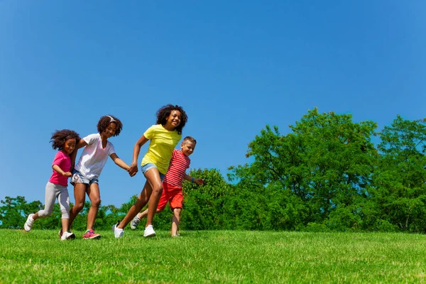手牵着手在公园里跑来跑去的孩子们的侧视图 — 图库照片