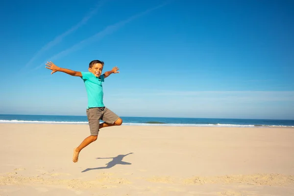 Glücklicher Kleiner Junge Springt Auf Den Sandstrand Mit Dem Meer — Stockfoto