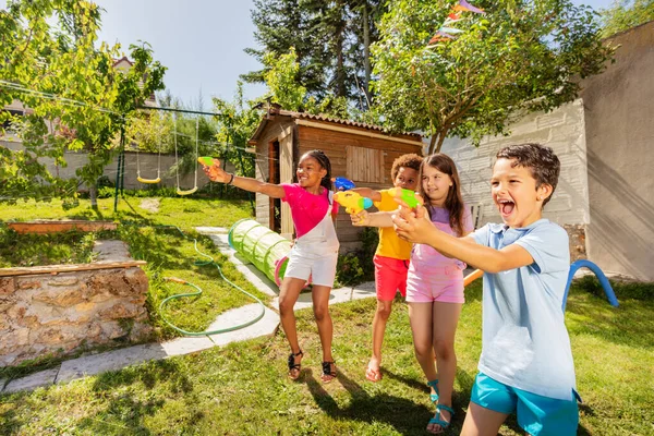 Group Kids Play Water Squirt Gun Game Lawn Backyard Laughing — Stock Photo, Image