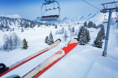 Bir çift kayak üzerini örttü ve dağların önünde ağır kar yağışı ve kaygan sandalyelerle tepeleri kapladı