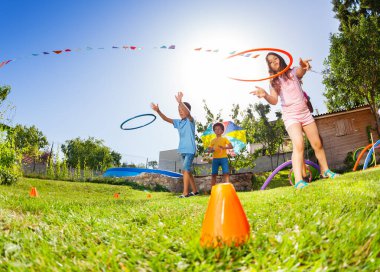 Oyun alanının çimlerinde hula hoop halkaları ile çeşitli oyun hedef oyunu uygulama grubu