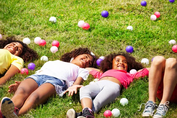 女の子のグループは 草や笑顔の周りの色のボールで 上からの眺めに横たわっていた — ストック写真