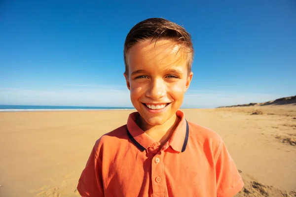 在长长的沙滩上快乐地微笑着的小白脸男孩画像 — 图库照片