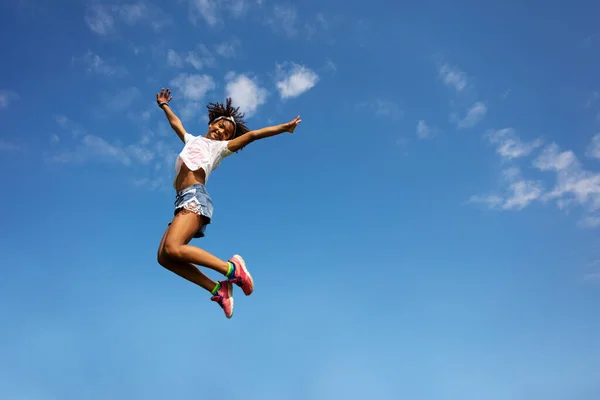 Feliz Joven Rizado Chica Negra Salto Alto Sobre Cielo Azul —  Fotos de Stock