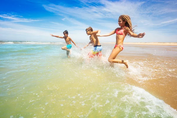 Grupo Niños Niñas Felices Saltan Las Olas Agua Mar Tomados —  Fotos de Stock