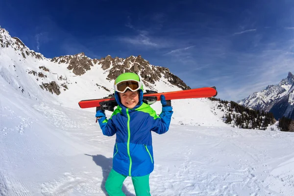 幸せな笑顔男の子とともに持ち上げマスク身に着けてヘルメット歩く雪の上に山のピーク — ストック写真