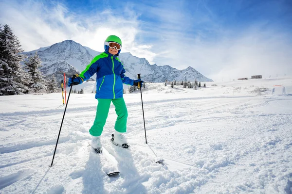 スキーマスクとヘルメットが空の斜面のパスの側に立って青い冬の服の少年は 高い山脈のピークの上にスキー場 — ストック写真