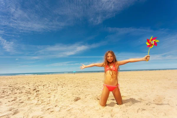 Niña Hermosa Con Molinete Pie Rodillas Sonriendo Playa Sobre Mar —  Fotos de Stock