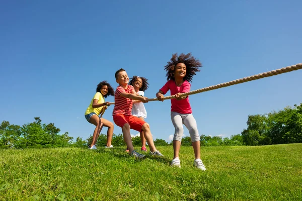 Grupa Dzieci Ciągnąć Linę Silną Siłą Emocjami Nad Błękitnym Niebem — Zdjęcie stockowe