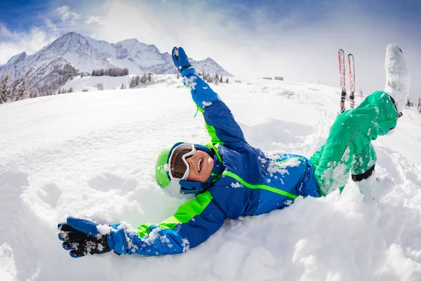男の子は笑って 深い雪の中で圧延スキー服を着て 晴れた冬の日に高い山の峰の上にヘルメットとマスク — ストック写真