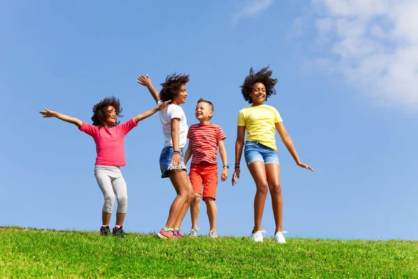 Grupa Szczęśliwych Tańców Skakanie Dzieci Zróżnicowane Patrząc Błękitne Niebo — Zdjęcie stockowe