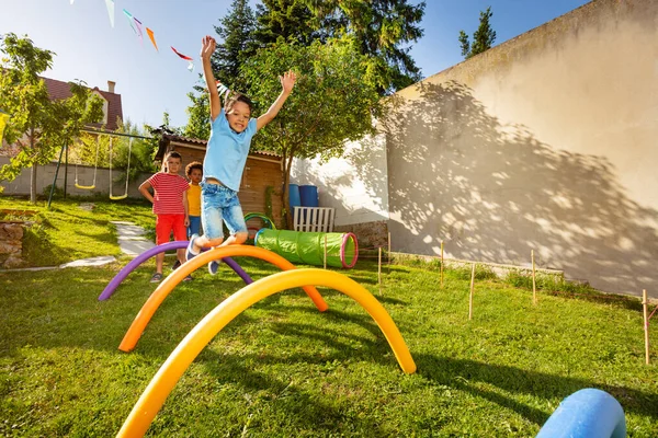 Groep Kinderen Springen Obstakels Kleine Achtertuin Speeltuin Een Rij Een — Stockfoto