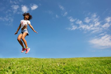 Kıvırcık saçlı ve mutlu çığlık atan heyecanlı yüzlü bir kız sahaya atlıyor.