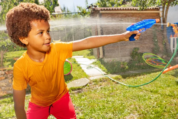 Маленький Чёрный Мальчик Вьющимися Волосами Жёлтой Футболкой Стреляет Водяного Пистолета — стоковое фото