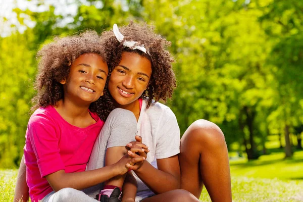 Closeup Two Girls Sisters Hold Hands Sitting Lawn Park — Stock Photo, Image