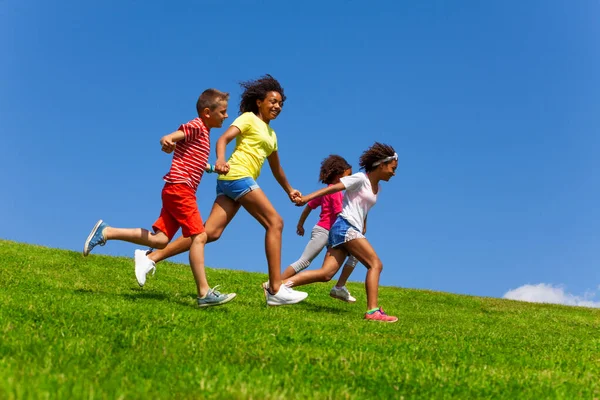 Cuatro Niños Felices Aspecto Diverso Corren Parque Sobre Cielo Azul —  Fotos de Stock