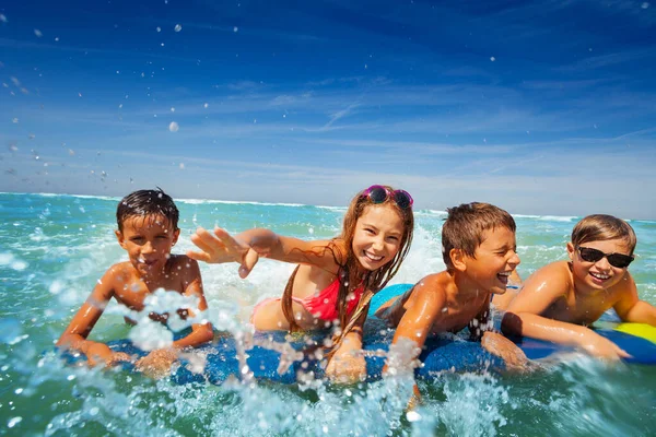 子供たちの大きな楽しい肖像画一緒に笑顔と笑ってボード上の海で泳ぐスプラッシュ — ストック写真