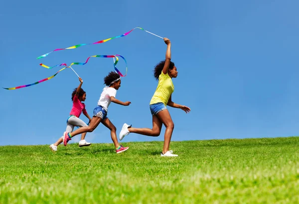 Salto Felice Tre Ragazze Onda Con Nastro Sopra Cielo Blu — Foto Stock