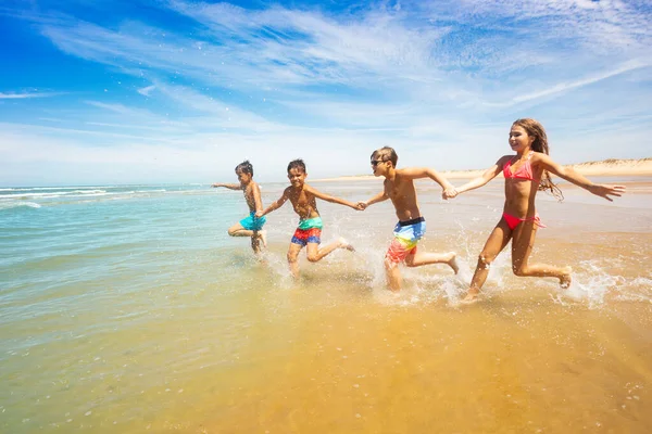 Grupo Niños Felices Corren Mar Tomados Mano Playa Arena —  Fotos de Stock