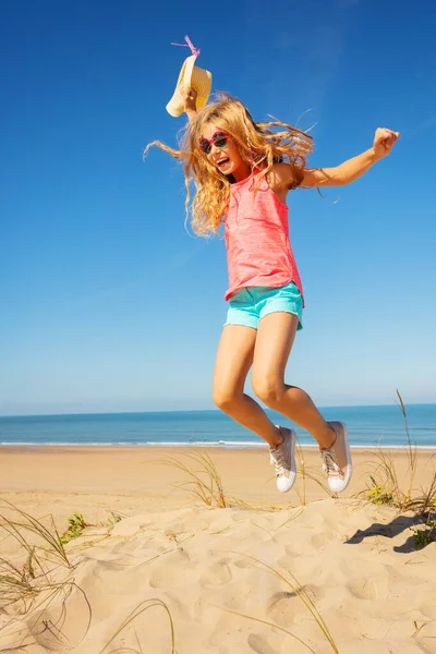 Счастливая Маленькая Девочка Длинными Волосами Держа Соломенную Шляпу Прыгать Высоко — стоковое фото