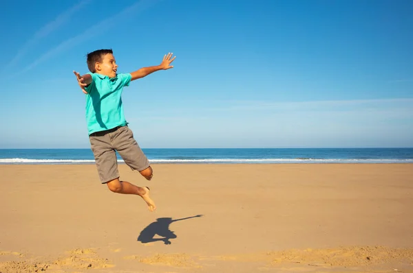 Glücklicher Kleiner Junge Springt Auf Den Sandstrand Mit Meer Hintergrund — Stockfoto