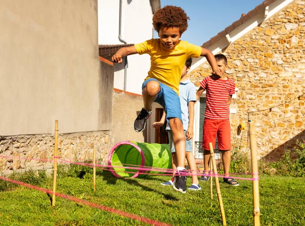 Grupo Diversos Niños Salto Uno Tras Otro Sobre Obstáculos Hechos —  Fotos de Stock