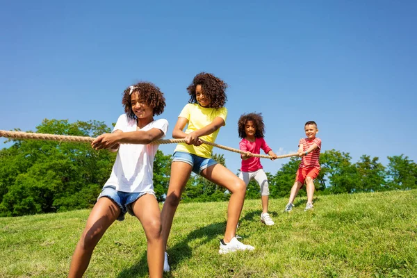 グループ多様な子供がロープを引く 夏の晴れた日に公園で競争力のある楽しいゲーム — ストック写真