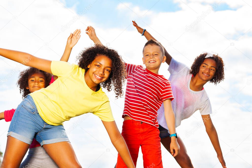 Close shoot of a group of boy and girls smile bending, leaning with hands in fly pose