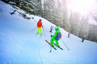 Çocuklar arka arkaya kayak yapmayı öğreniyorlar.
