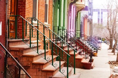 New York, ABD 'deki Lancaster Caddesi' ndeki tipik Albany evlerinin renkli merdiven ve tırabzanları.