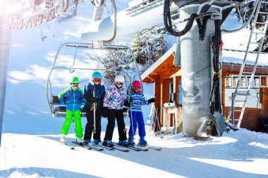 Bir grup çocuk dağ istasyonunun tepesinde, Alp Tatil Köyü 'nde teleferikle havalanıyorlar.