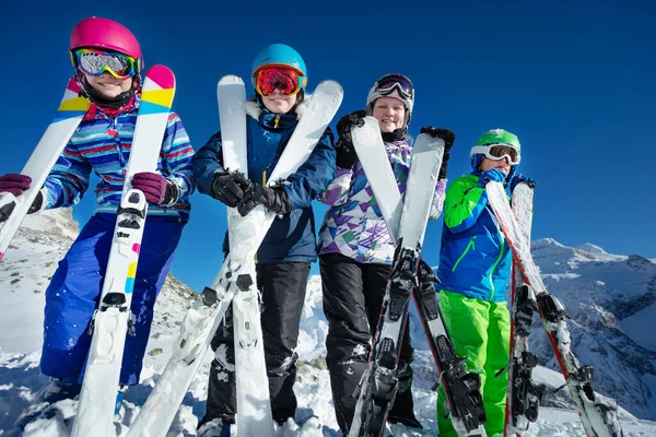 スキー休暇の肖像画多くの子供たちは カラーグーグルとヘルメットを身に着けているカメラにもたれる手のスポーツ用品で立つ — ストック写真