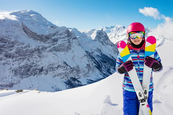 ピンクのヘルメットとカラースキーでかわいい女の子のフロント顔の肖像画 高い山の上のゴーグル — ストック写真