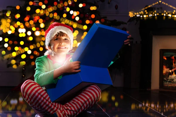 Menino Feliz Abre Brilhante Caixa Presente Natal Sentado Perto Árvore — Fotografia de Stock