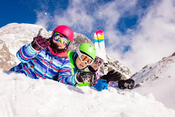 一群快乐的滑雪孩子们 男孩和女孩们一起躺在雪地里 一排排 背对着山 微笑着看着摄像机 — 图库照片