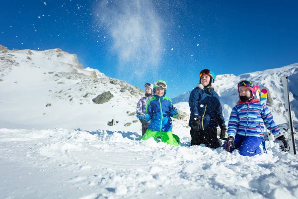 子供たちのグループの肖像画は 美しい山の上に空気中の雪を投げる地面に横たわっていた — ストック写真