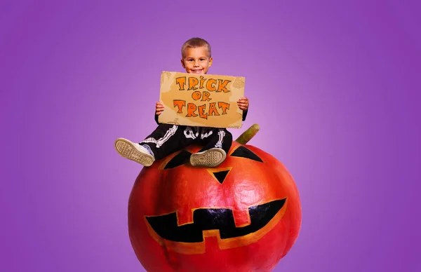 Junge Mit Trick Oder Leckerli Zeichen Sitzen Auf Halloween Kürbis — Stockfoto