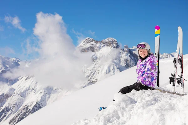 Счастливая Девушка Лыжном Костюме Шлеме Маске Сидит Снегу Вершине Горы — стоковое фото