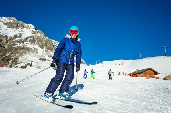 冬の晴れた日にアルパインリゾートを背景に子供たちとカラフルな衣装スキーで10代の女の子の肖像画 — ストック写真