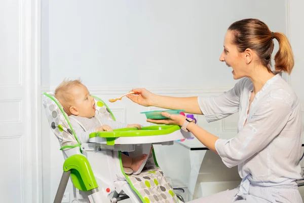 Glad Liten Småbarn Pojke Sitta Barnstol Och Äta Från Plastsked — Stockfoto