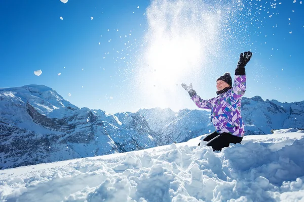 快乐的少年漂亮的滑雪女孩的肖像把雪扔向空中 坐在山顶的景色上 — 图库照片